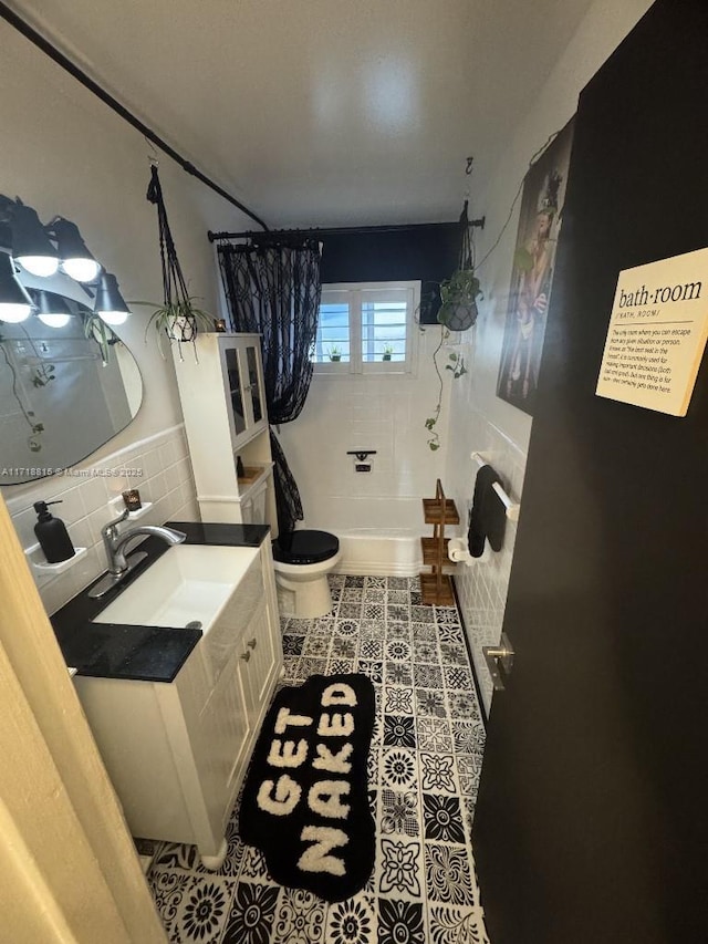 full bathroom featuring shower / bath combo, tile walls, vanity, tile patterned floors, and toilet