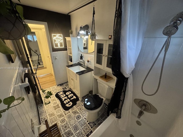 interior space featuring white cabinetry, sink, tile walls, and light wood-type flooring