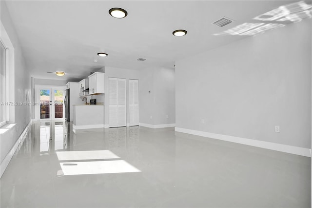 empty room with sink, concrete floors, and french doors