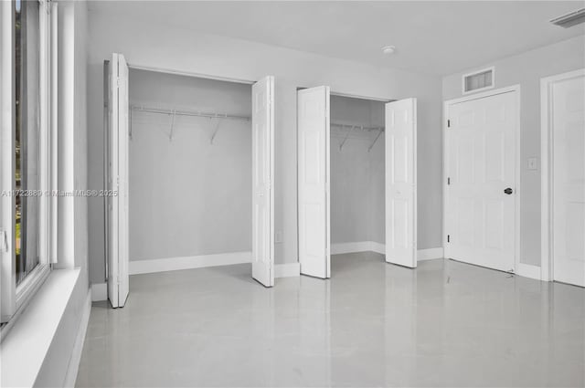 unfurnished bedroom featuring multiple closets