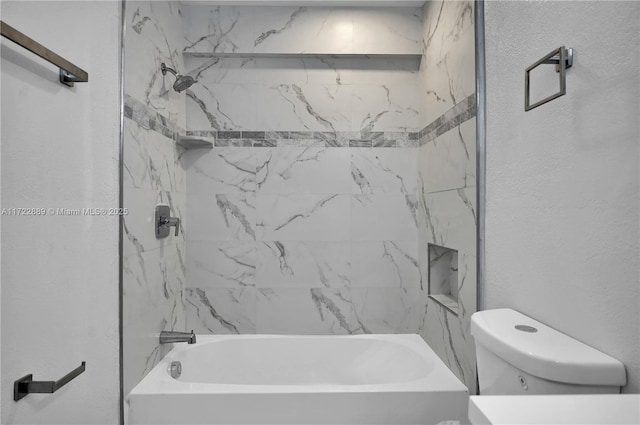 bathroom with toilet and tiled shower / bath combo