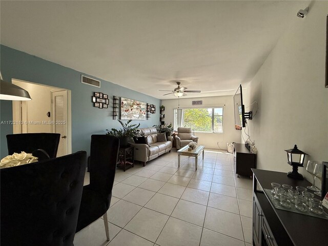 living room featuring light tile patterned floors, visible vents, and ceiling fan
