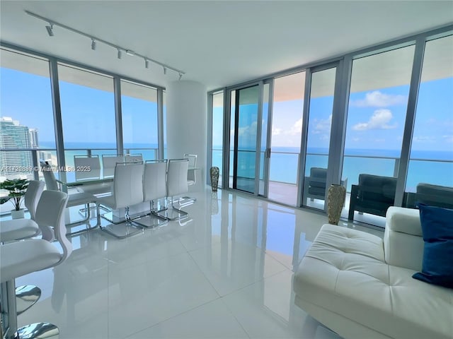 living room featuring tile patterned flooring, a water view, and track lighting