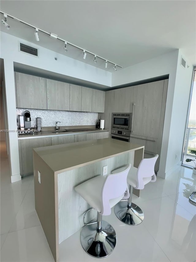 kitchen with appliances with stainless steel finishes, a center island, a kitchen breakfast bar, and sink