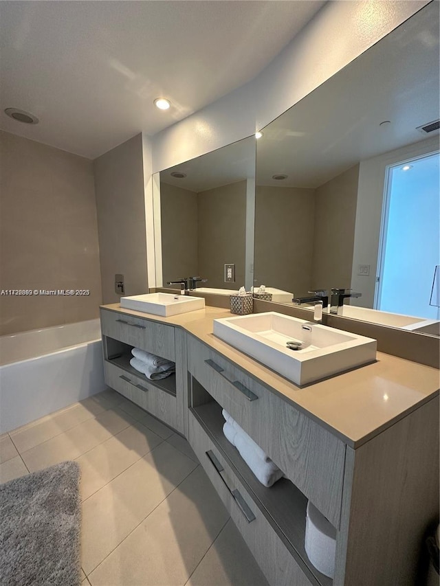 bathroom featuring tile patterned flooring, vanity, and a washtub