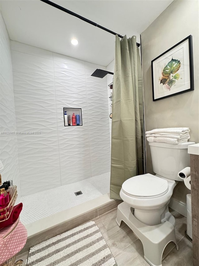 bathroom featuring toilet and a stall shower