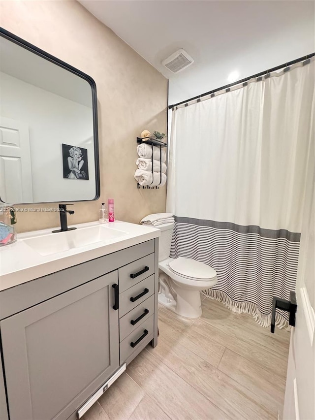 bathroom featuring toilet, visible vents, and vanity