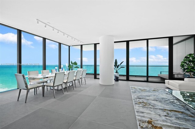 entryway featuring tile patterned flooring, a water view, and a healthy amount of sunlight