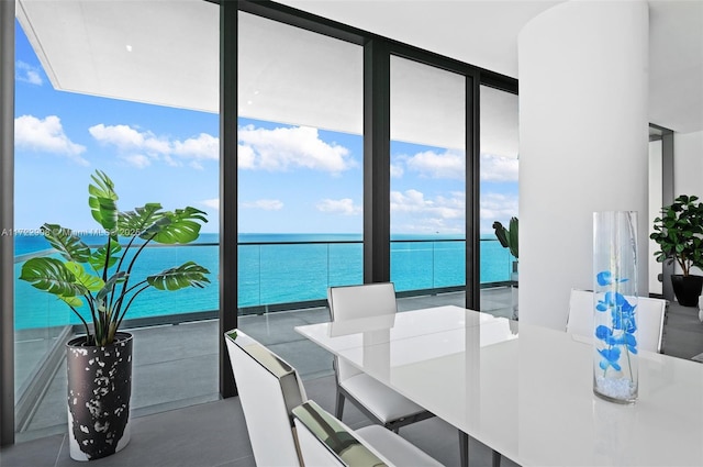 dining space with plenty of natural light, expansive windows, and a water view