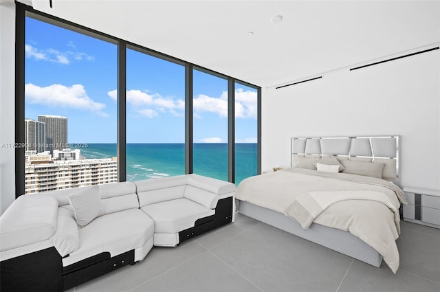 bedroom featuring a wall of windows and a water view