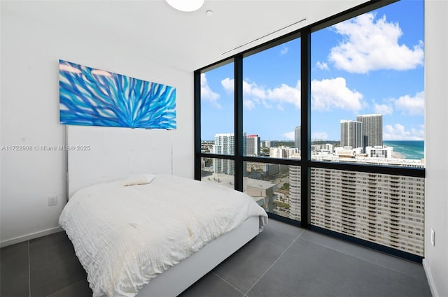 bedroom with a water view and a wall of windows