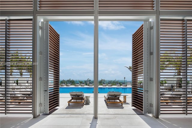 entryway featuring a water view, plenty of natural light, and tile patterned floors