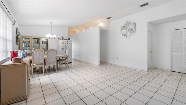 unfurnished dining area featuring light tile patterned floors and an inviting chandelier