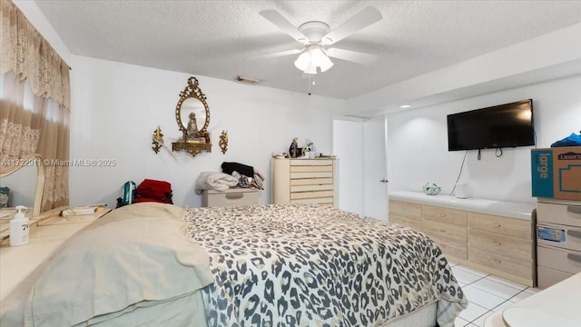 tiled bedroom with ceiling fan and a textured ceiling