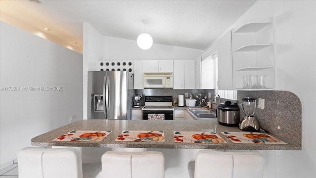 kitchen featuring stainless steel refrigerator with ice dispenser, sink, white cabinets, black / electric stove, and a breakfast bar area