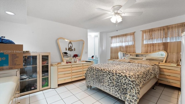 tiled bedroom with a textured ceiling and ceiling fan