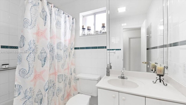 bathroom featuring vanity, toilet, tile walls, and walk in shower