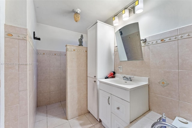 bathroom with tile patterned flooring, vanity, and tile walls