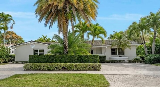 ranch-style house featuring decorative driveway and stucco siding