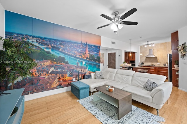 living room with ceiling fan and light hardwood / wood-style flooring