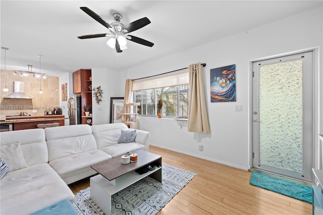 living room featuring ceiling fan and light hardwood / wood-style flooring