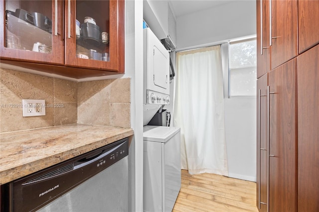 washroom featuring light hardwood / wood-style flooring and stacked washing maching and dryer