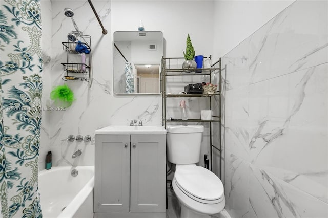 full bathroom with vanity, toilet, shower / bath combo with shower curtain, and tile walls