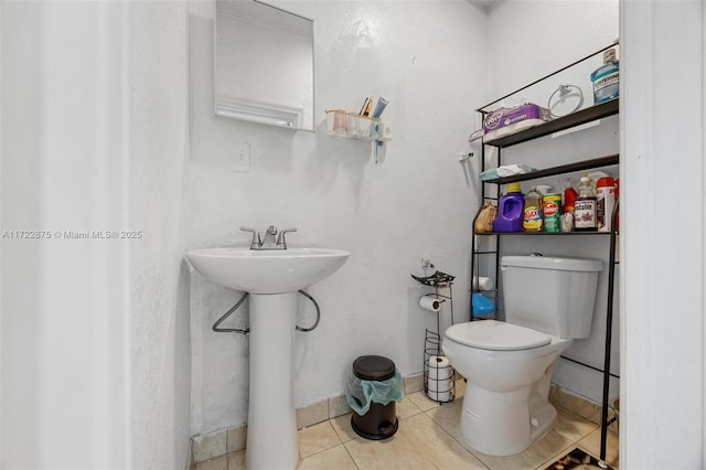 bathroom with tile patterned flooring, toilet, and sink