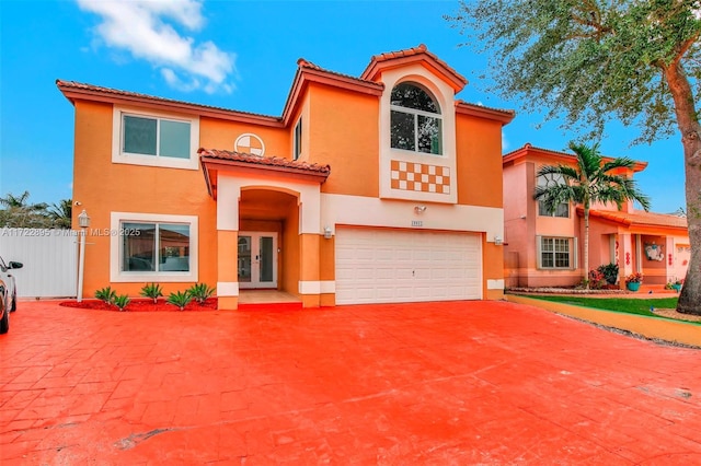 mediterranean / spanish-style home featuring a garage and french doors