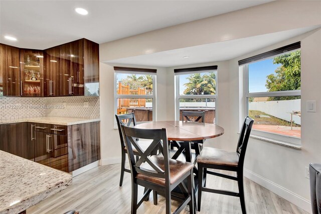 dining room with light hardwood / wood-style floors and a water view