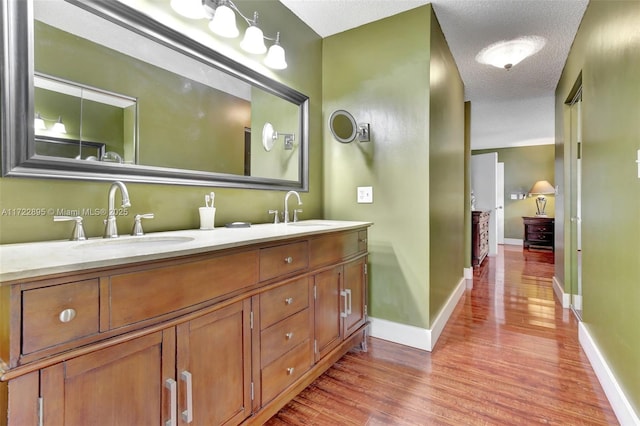 bathroom with vanity, a textured ceiling, and hardwood / wood-style flooring