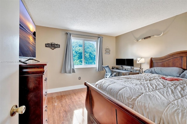 bedroom with a textured ceiling and light wood-type flooring