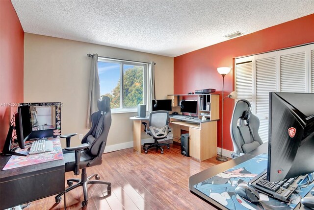 home office featuring a textured ceiling and light wood-type flooring