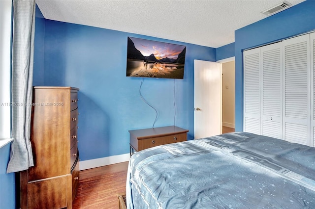 bedroom featuring a closet, a textured ceiling, and hardwood / wood-style flooring