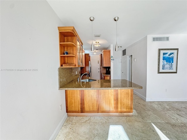 kitchen with sink, hanging light fixtures, kitchen peninsula, stone countertops, and decorative backsplash