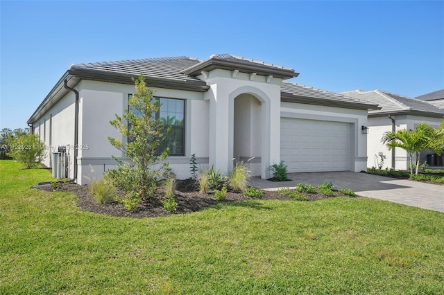 view of front of house featuring a garage, a tiled roof, a front yard, and decorative driveway