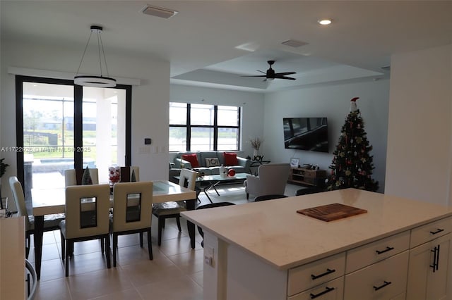 tiled dining area featuring french doors, ceiling fan, and a tray ceiling