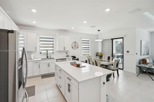 kitchen featuring white cabinetry, a sink, stainless steel appliances, and a healthy amount of sunlight