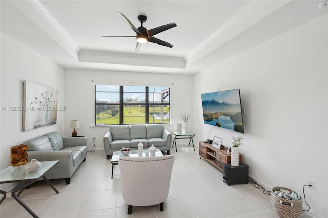 living area with a ceiling fan, ornamental molding, and a raised ceiling