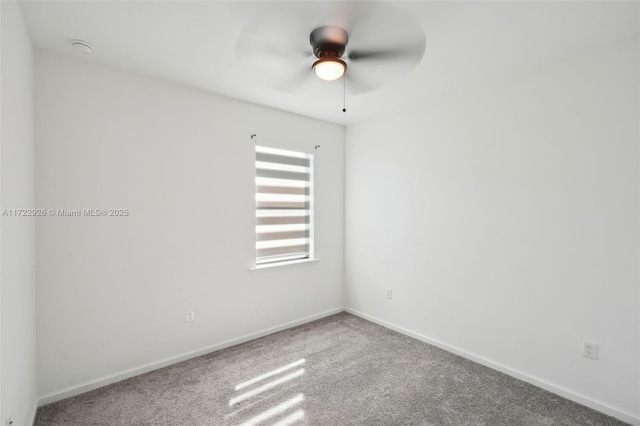 carpeted spare room with baseboards and ceiling fan