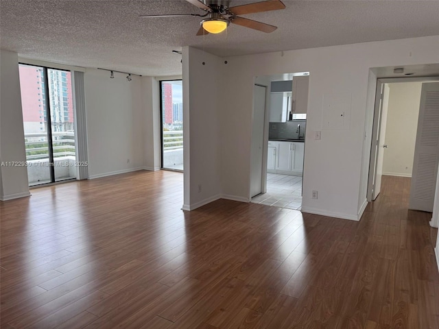 unfurnished room featuring hardwood / wood-style flooring, sink, a textured ceiling, and ceiling fan