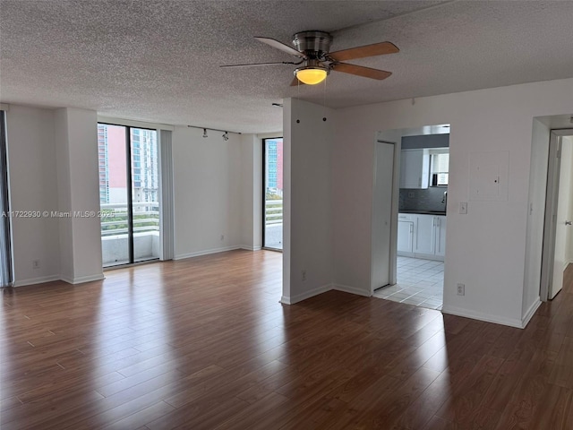 unfurnished room featuring expansive windows, a textured ceiling, and light hardwood / wood-style flooring