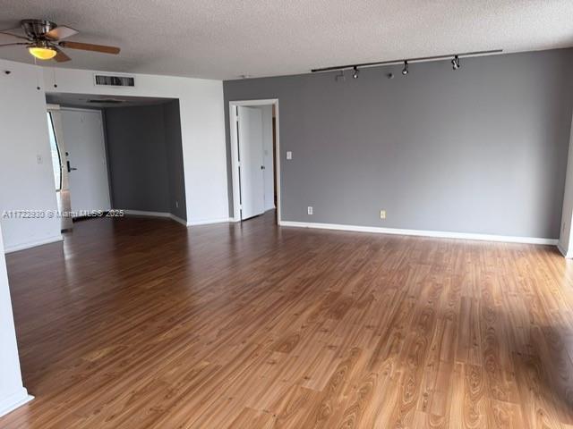 empty room featuring hardwood / wood-style flooring, ceiling fan, and a textured ceiling