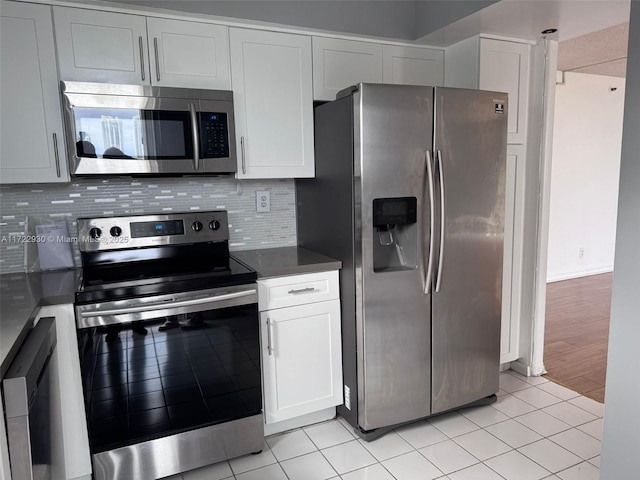 kitchen featuring white cabinetry, appliances with stainless steel finishes, tasteful backsplash, and light tile patterned floors