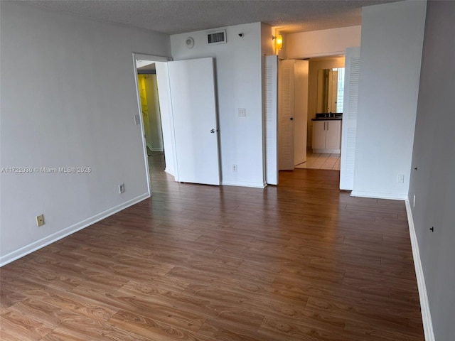 empty room with hardwood / wood-style flooring and a textured ceiling