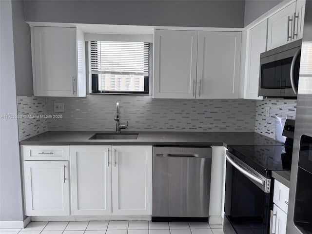 3300 NE 192nd St Unit 918, Aventura, FL 33180 - kitchen with a sink, stainless steel appliances, backsplash, dark countertops, and white cabinets