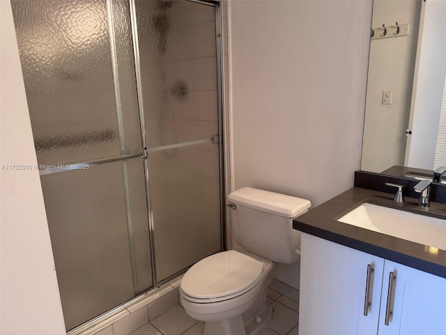 bathroom with tile patterned flooring, vanity, toilet, and walk in shower