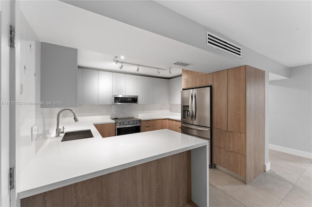 kitchen with sink, white cabinetry, appliances with stainless steel finishes, light tile patterned flooring, and kitchen peninsula