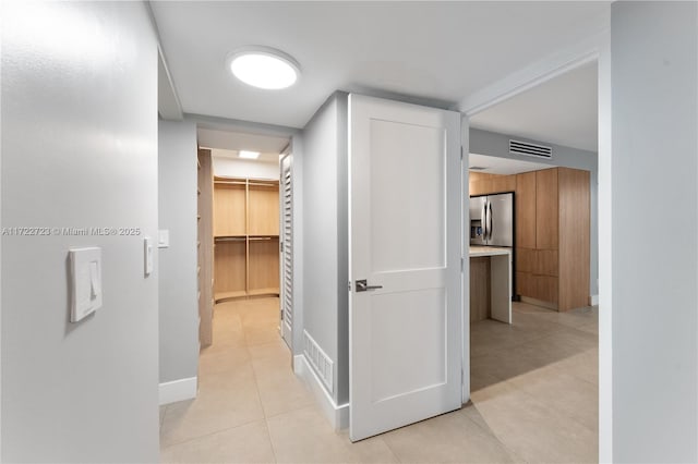 hall featuring light tile patterned floors