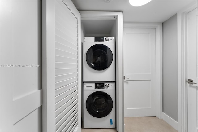 clothes washing area featuring stacked washer and clothes dryer